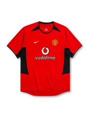 Manchester United 2002-04 home jersey, front view, red body with black angular shoulder and side panels, black crew neck collar, black sleeve trim, Nike swoosh logo, club crest, Vodafone sponsor logo