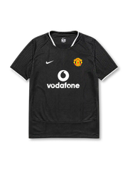 Manchester United 2003-04 away jersey, front view, black body with tonal geometric pattern, white ringer collar and cuffs, Nike swoosh logo, club crest, Vodafone sponsor logo