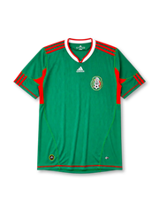 Mexico 2010 home jersey, front view, green body with red side panels, red and white V-neck collar, white adidas logo and stripes, Mexican Football Federation eagle crest, red hem stripe, small adidas and ClimaCool tags