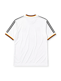 West Germany 1986 home jersey, front view, white body with black red and gold tricolor V-neck collar trim, black adidas trefoil logo and stripes, circular DFB eagle crest, tricolor trimmed cuffs