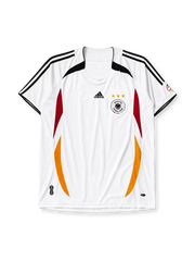 Germany 2006 home jersey, front view, white body with curved red and gold side panels, black shoulder panels, black adidas logo and stripes, three gold stars, DFB eagle crest, small tournament emblem on sleeve