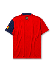 Spain 1996 home jersey, front view, red body with asymmetric navy side panel, navy button-placket collar, yellow adidas logo and stripes, Spanish royal crest, small Spain flag patch on sleeve, Federacion Espanola de Futbol tag near hem