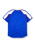 Japan 2000 home jersey, front view, blue body with white shoulder panels and red trim, white polo-style collar with red zip placket, small Japan flag emblem, JFA crest with three-legged crow, Japan text beneath crest