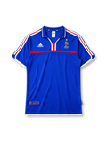 France 2000 home jersey, front view, royal blue body with white and red tricolor adidas stripes, blue polo-style collar with red placket accent, gold F.F.F. rooster crest with star, red chest band, FFF authentic product tag near hem