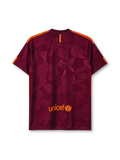Barcelona 2017-18 third jersey, front view, deep maroon body with tonal geometric crackled pattern, orange shoulder accents, crew-neck collar, orange Nike swoosh, Barcelona crest, white Rakuten sponsor logo, black and red striped side panels