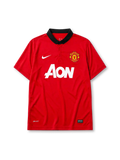 Manchester United 2013-14 home jersey, front view, red body, black polo-style collar with button placket, white Nike swoosh, Manchester United crest, white AON sponsor logo