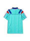 Barcelona 1992-95 away jersey, front view, mint turquoise body with repeated Barca script pattern, blue polo-style collar, red and blue diagonal shoulder panels, Kappa logo, Barcelona crest, blue Barca script wordmark