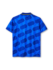 Colombia 1994 away jersey, front view, royal blue body with tonal diamond pattern and darker football-panel print, navy polo collar with yellow tipping and V insert, yellow UMBRO wordmark on right chest, Colombian Football Federation crest on left chest