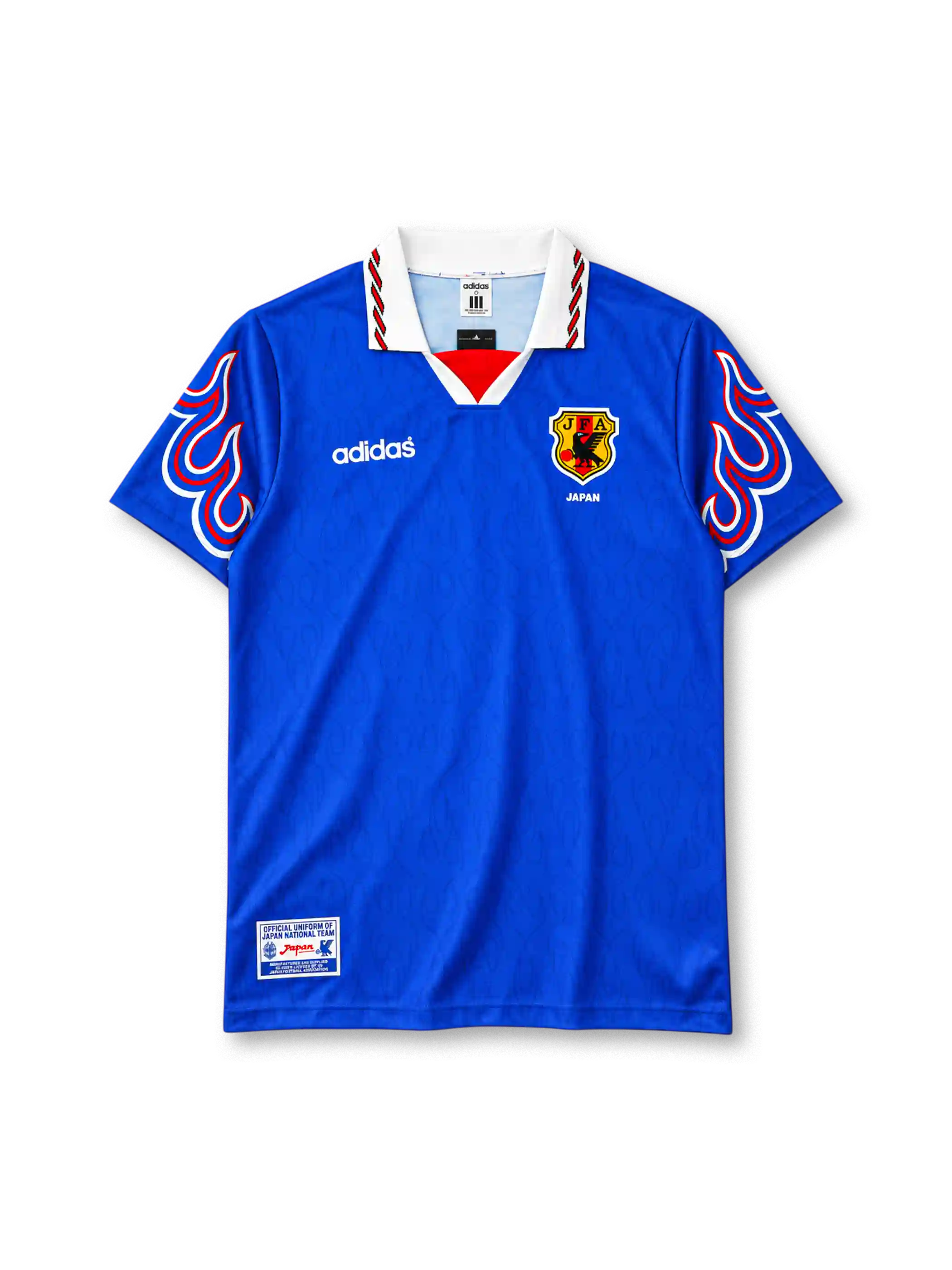 Japan 1996-97 home jersey, front view, royal blue body with tonal pattern, white polo collar with red and black stripe trim, red V insert, red white and blue flame graphics on both sleeves, white adidas wordmark on right chest, JFA crest with JAPAN text on left chest, official uniform label at hem