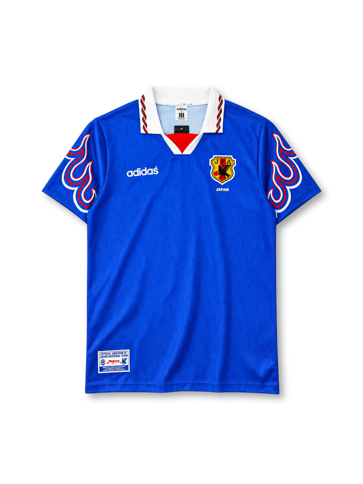 Japan 1996-97 home jersey, front view, royal blue body with tonal pattern, white polo collar with red and black stripe trim, red V insert, red white and blue flame graphics on both sleeves, white adidas wordmark on right chest, JFA crest with JAPAN text on left chest, official uniform label at hem