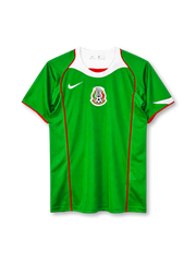 Mexico 2004 home jersey, front view, green body, white curved collar yoke with red trim, red piping down the front, white Nike swoosh on right chest, Mexican Football Federation crest centred on chest, red sleeve trim, white accent on left sleeve