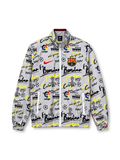 Front view of a white FC Barcelona-inspired graffiti track jacket featuring black and neon yellow lettering, soccer ball and trophy graphics, LaLiga-inspired motifs, a red Nike Swoosh, colorful Barcelona crest, full zipper, and elasticated cuffs.