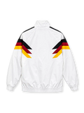 Front view of a white Germany 1990 World Cup retro track jacket featuring black, red, and gold chevron graphics across the chest and sleeves, a black adidas Trefoil logo, circular DFB crest, stand-up collar, full zipper, and elasticated cuffs.