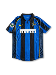 Front view of Inter home shirt in black and blue stripes with Pirelli sponsor, yellow swoosh, club crest, fold-over collar, and league sleeve patch.