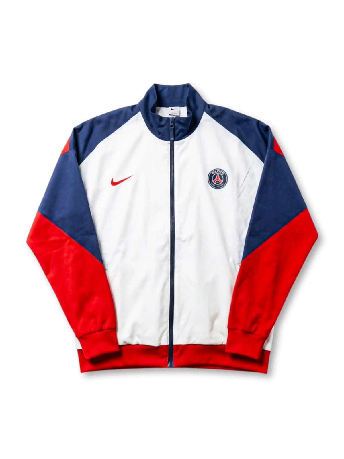 Paris Saint-Germain Nike track jacket with white body, navy raglan shoulder panels, red sleeves, red Nike Swoosh at left chest, and embroidered PSG crest at right chest