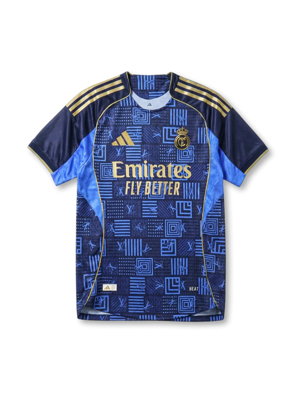 Real Madrid × adidas × Louis Vuitton away jersey in navy with LV geometric monogram patchwork print, sky blue side panels, gold Three Stripes on shoulders, gold adidas logo at left chest, gold Real Madrid crest at right chest, Emirates gold sponsor