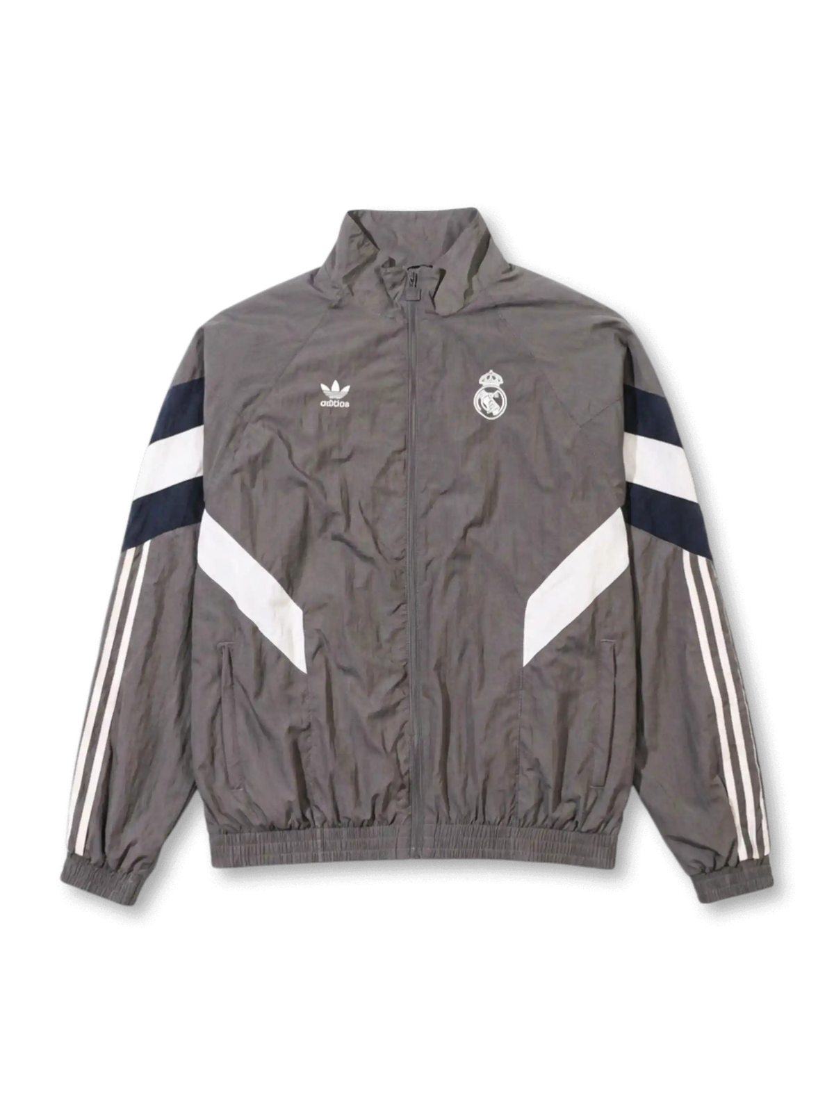 Real Madrid adidas Originals retro track jacket in charcoal grey with navy and white chevron panels, Trefoil logo and embroidered crest at chest, Three Stripes on sleeves