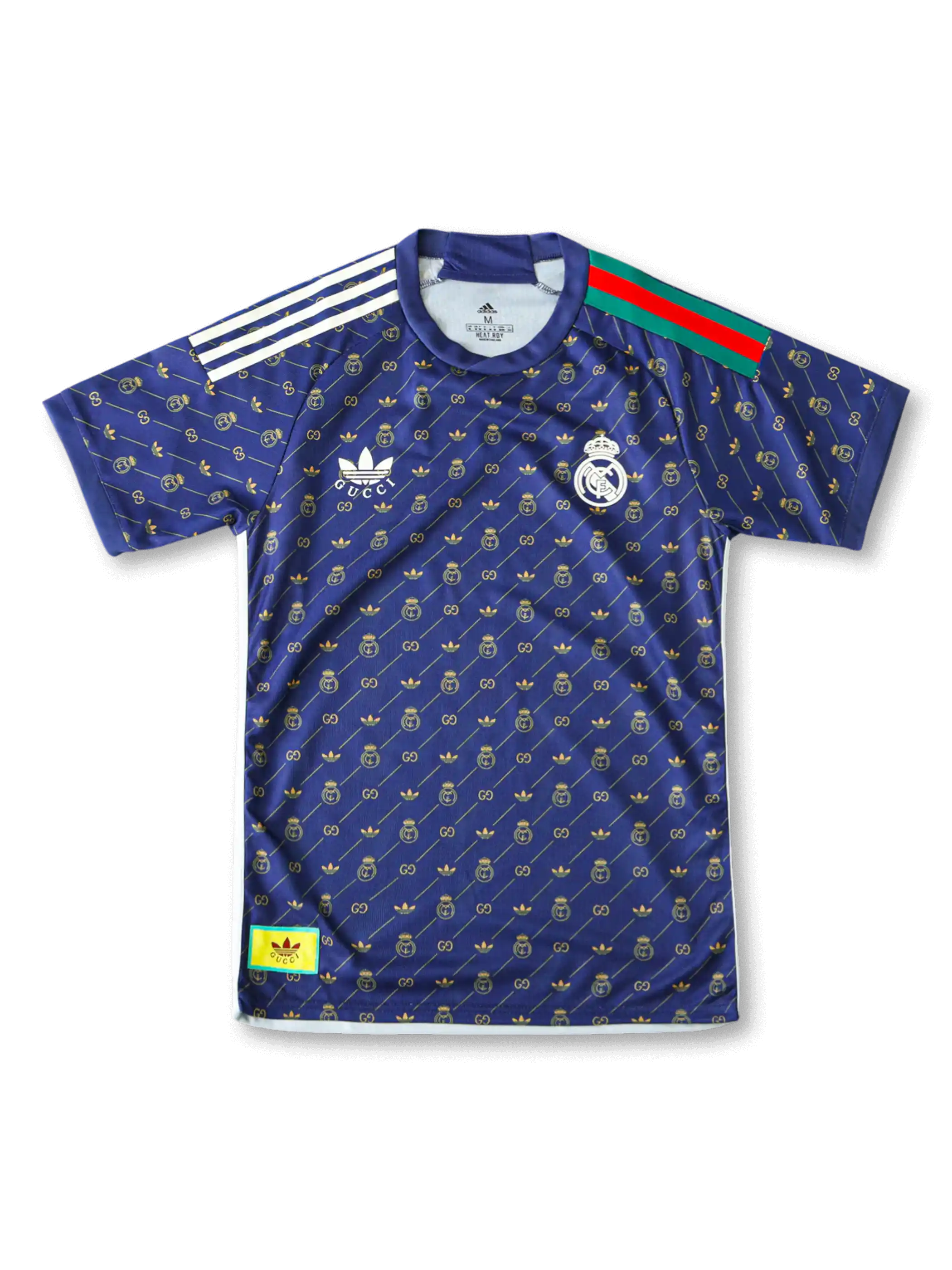 Front view of Real Madrid special edition shirt in navy with gold monogram pattern, crest, trefoil-style chest logo, and striped shoulder detail.
