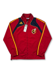 Deadstock Spain national team adidas track jacket in red with curved navy and yellow shoulder panels, yellow Three Stripes, yellow adidas logo at left chest, RFEF centenary crest badge at right chest, original retail tags attached