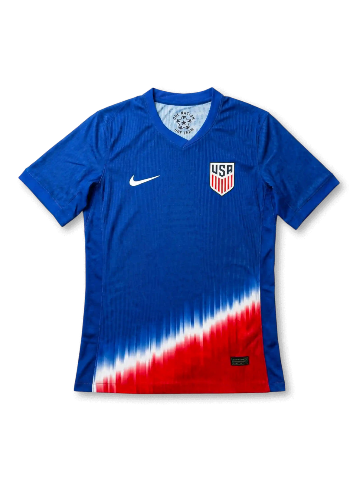 USA national team Nike 2024/25 away jersey in royal blue with tonal vertical pinstripe texture, dramatic diagonal red, white, and blue gradient fade at hem, white Swoosh at left chest, USA shield crest at right chest