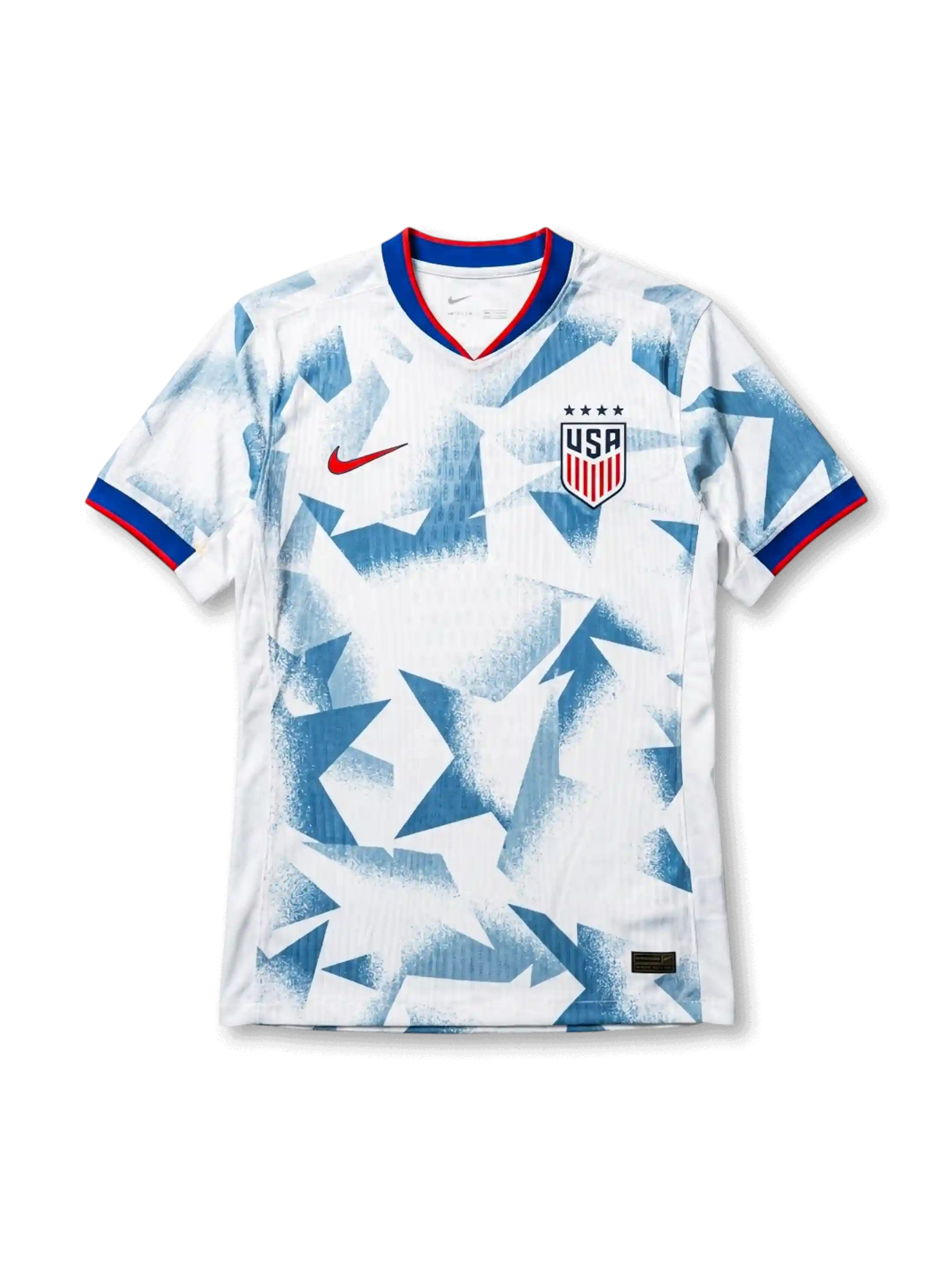 USA national team Nike 2025/26 World Cup home jersey in white with full-surface angular geometric grey shatter-camo print, tricolor V-neck collar in red and blue, red Swoosh at left chest, USA shield crest at right chest, red and blue sleeve cuff bands